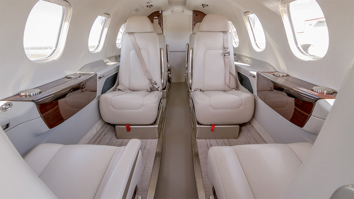 Phenom 300 cabin interior with executive club seating and natural light